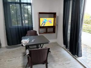 a living room with a table and a television in a room at M Tower Appartment in Post of Flacq