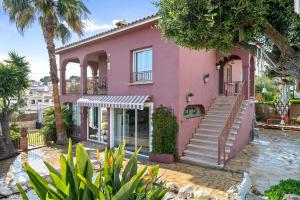 una casa rosa con una escalera delante en Villa Maravillosa, en Cunit