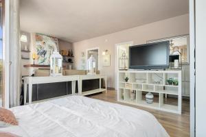 a bedroom with a bed and a flat screen tv at Villa Maravillosa in Cunit