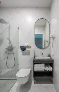 bagno con servizi igienici, lavandino e specchio di GENIO 7 apartamentai a Palanga