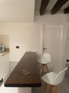 eine Küche mit einem Tisch und 2 weißen Stühlen in der Unterkunft Ca' Sant'Aponal 2 in Venedig