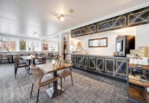 a dining room with tables and chairs and a bar at Hotel Hjallerup Kro in Hjallerup