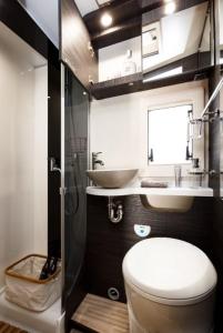 a bathroom with a toilet and a sink at Camper met sauna en zwembad in de rand van de Vlaamse Ardennen in Haaltert