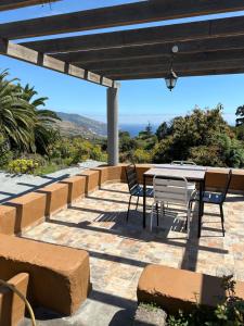 un patio con mesa, sillas y el océano en Casa Asuncion, en Breña Alta
