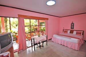1 dormitorio con 1 cama, TV y balcón en Bangburd Resort, en Ban Khiam En