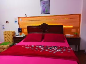 - une chambre avec un lit rose et une tête de lit en bois dans l'établissement Fayrouzat Almndra near the sea with garden view, à Alexandrie