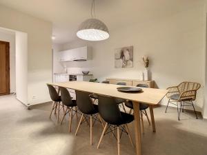 a dining room with a wooden table and chairs at Mooi Maaseik in Maaseik