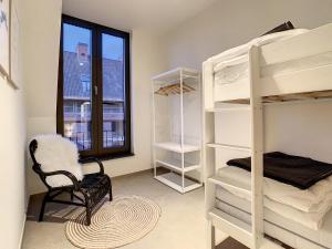 a room with bunk beds and a chair and a window at Mooi Maaseik in Maaseik
