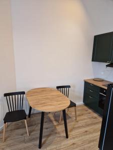 eine Küche mit einem Holztisch und 2 Stühlen in der Unterkunft Kamienica Bydgoska Paula Storza in Bydgoszcz