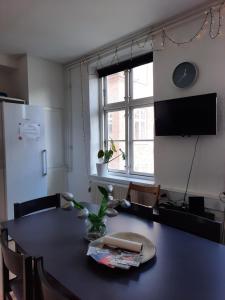 Habitación con mesa y cocina con nevera. en 1- Bed Private room in apartment, en Odense