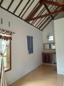 Zimmer mit weißen Wänden und Holzdecke in der Unterkunft Hakiki Inn Bungalows in Tetebatu