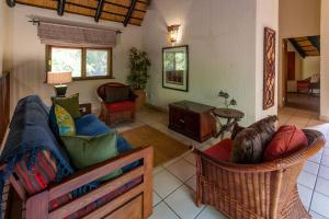 a living room with a couch and chairs at Kruger Park Lodge Unit No. 265 in Hazyview