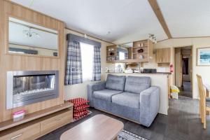 a living room with a couch and a tv at Beautiful 8 Berth Caravan At Cherry Tree Holiday Park In Norfolk Ref 70803c in Great Yarmouth