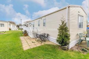 a house with a table and chairs in a yard at Beautiful 8 Berth Caravan At Cherry Tree Holiday Park In Norfolk Ref 70803c in Great Yarmouth