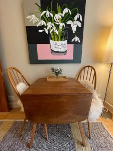a wooden table with a vase of flowers on it at Beautiful & Cosy 2BD House - Southwark in London
