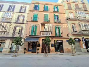 un edificio con ventanas coloridas y árboles delante de él en Carreteria Pool ApartamentosMalagaManagement, en Málaga