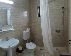 a bathroom with a sink and a toilet and a shower at Vila Bya in 2 Mai