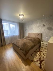 ein Schlafzimmer mit einem großen Bett und einem Teppich in der Unterkunft APARTMENT PREMIUM VIP in Berdychiv