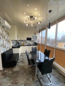 a kitchen with a dining room table and chairs at APARTMENT PREMIUM VIP in Berdychiv