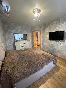 ein Schlafzimmer mit einem großen Bett und einem Flachbild-TV in der Unterkunft APARTMENT PREMIUM VIP in Berdychiv