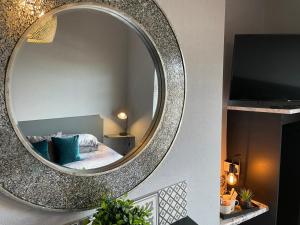 a mirror on a wall with a bed in a room at The Vines Lodge in Cleethorpes