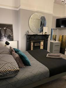 a bedroom with a bed with a fireplace and a mirror at The Vines Lodge in Cleethorpes