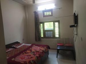 1 dormitorio con 1 cama, 1 silla y 1 ventana en Jagan Hotel And Restaurant en Bhara