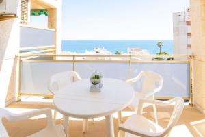 a white table and chairs on a balcony with the ocean at Rentalmar Nabila in Miami Platja