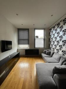 a living room with a couch and a tv at Stylish 1BD Flat - 1 Min from Bethnal Green in London