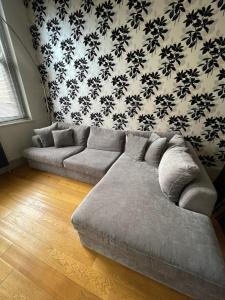 a couch in a living room with a wall at Stylish 1BD Flat - 1 Min from Bethnal Green in London