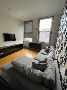 a living room with a couch and a tv at Stylish 1BD Flat - 1 Min from Bethnal Green in London