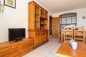 a living room with a tv and a wooden entertainment center at Rentalmar Nabila in Miami Platja