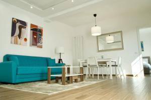 a living room with a blue couch and a table at Residenza dei Molini Monza centro in Monza +11 photos