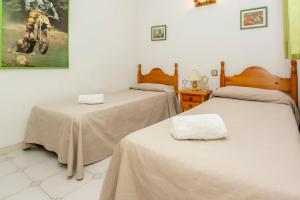 a room with two beds and a dirt bike painting on the wall at Rentalmar Nabila in Miami Platja +18 photos