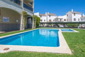 a swimming pool in a yard next to a building at Rentalmar Nabila in Miami Platja