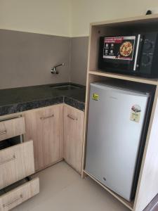 a kitchen with a refrigerator and a microwave at Starlit Suites Shirdi in Nighoj