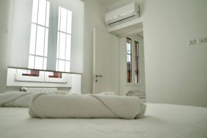 a white room with two large windows and a couch at Residenza dei Molini Monza centro in Monza