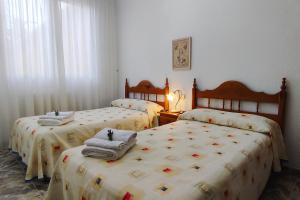 a bedroom with three beds with towels on them at Casa de invitados tradicional con piscina en la huerta de Lorca in Lorca