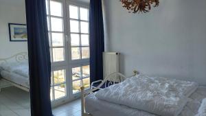 a bedroom with a bed and a large window at Haus Baltic Sellin by Rujana in Ostseebad Sellin