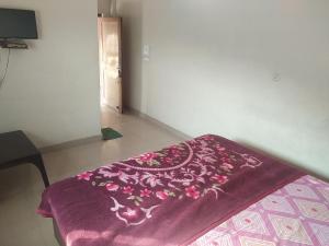 una manta morada en una cama en una habitación en Jagan Hotel And Restaurant en Bhara