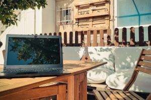 un ordenador portátil sentado en una mesa de madera en Casa de invitados tradicional con piscina en la huerta de Lorca, en Lorca