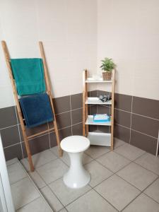 a bathroom with two chairs and a toilet at Quiétude et confort in Tallard