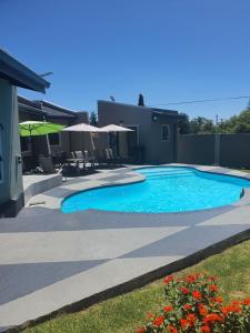 ein Schwimmbad in einem Hof neben einem Haus in der Unterkunft URlyfstyle 5 bedrooms near OR Tambo international Airport in Kempton Park