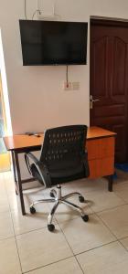 a desk with a chair and a computer monitor at Eagles nest III Furnished apartments in Nairobi