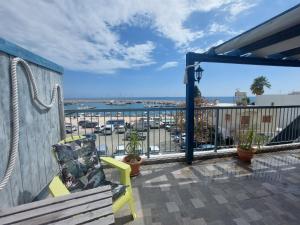 a balcony with a bench and a view of the water at Penthouse with roof garden in Zygi village Marina in Larnaca