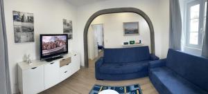 sala de estar con sofá azul y TV en Casa do Porto, en Angra do Heroísmo