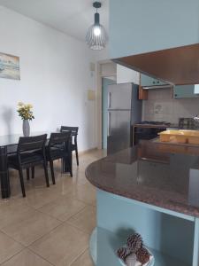 a kitchen with a counter and a table with chairs at Penthouse with roof garden in Zygi village Marina in Larnaca