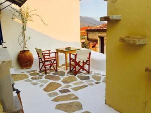 a patio with a table and chairs on a stone floor at Angela's House in Koumeika