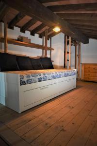 a bed sitting on a wooden floor in a room at [Sea Garden] Elegant Villa with a View in Rio nellʼElba
