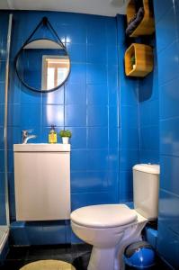 a blue bathroom with a toilet and a mirror at Appartement 1er arrondissement in Marseille